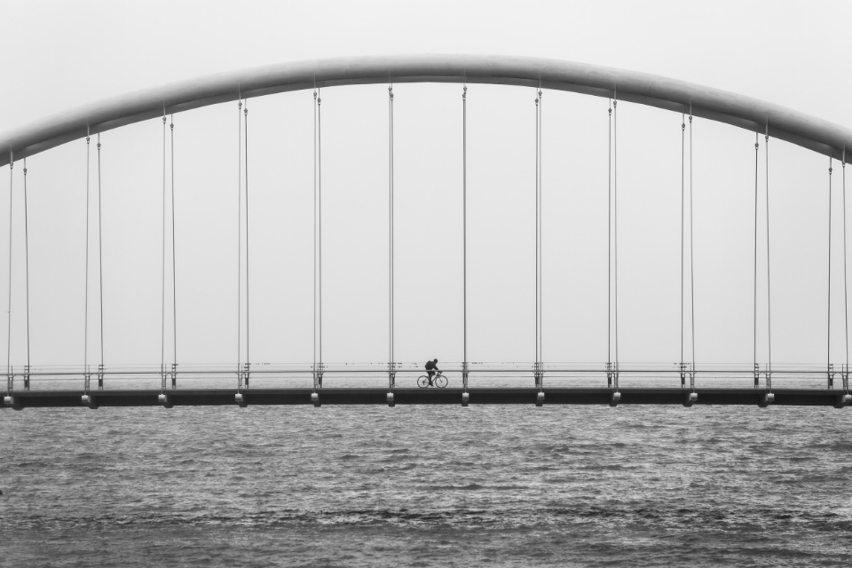 picture of a cyclist on a suspension bridge
